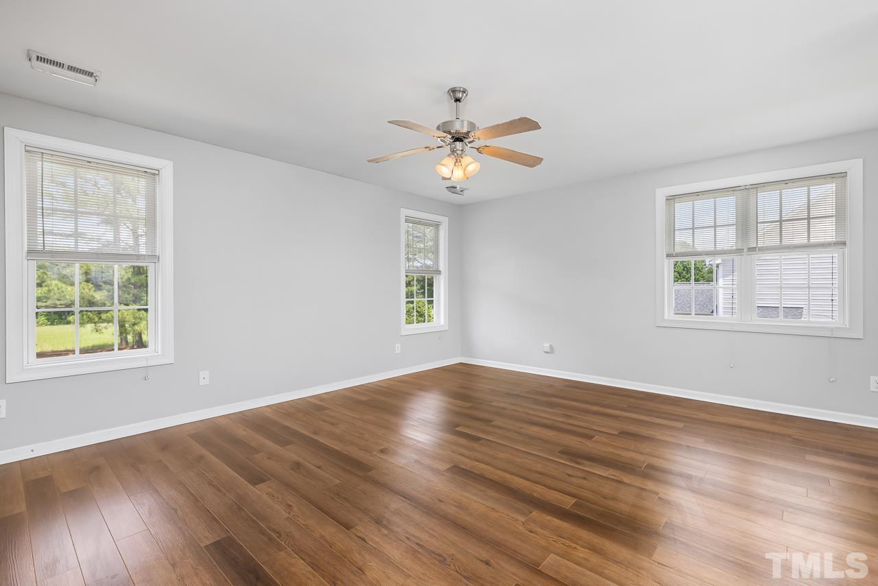 65 Bess Lane Angier, NC 27501 - Photo 32 of 38 a view of empty room with wooden floor and fan