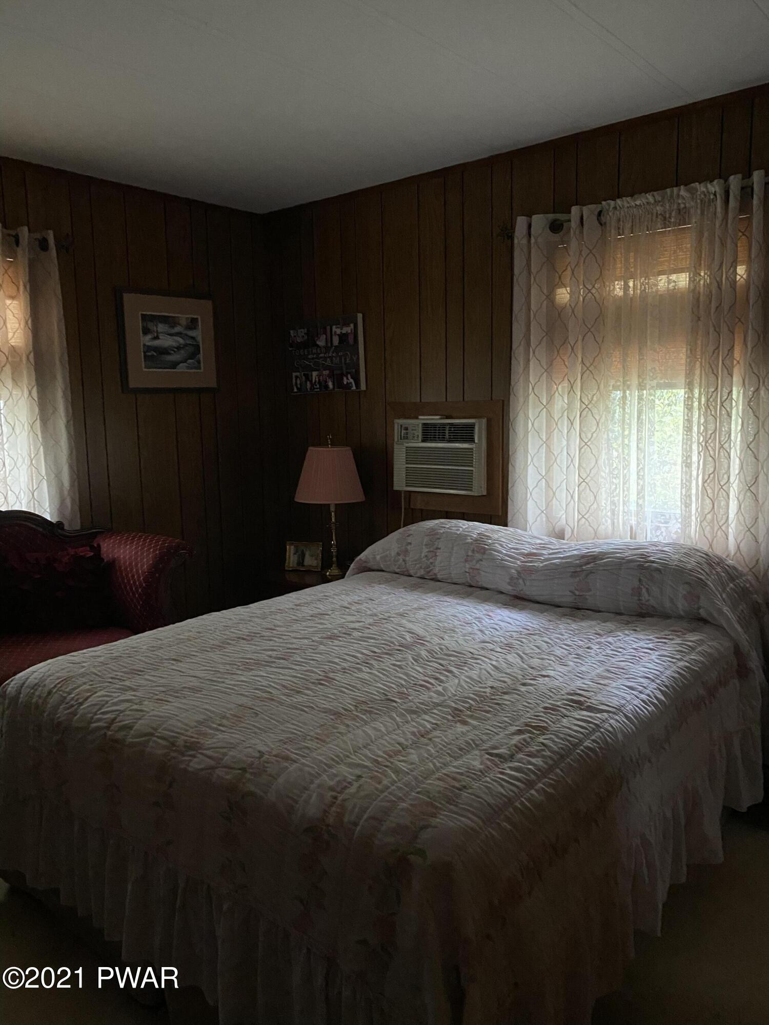 125 Maple Ridge Drive Hawley, PA 18428 - Photo 16 of 49 a bedroom with a bed and a large mirror