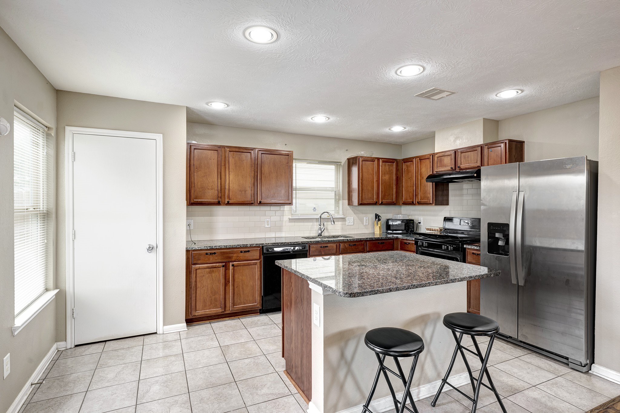 18953 Bobcat Path Houston, TX 77073 - Photo 7 of 21 a kitchen with stainless steel appliances granite countertop a refrigerator a sink a stove a microwave and island