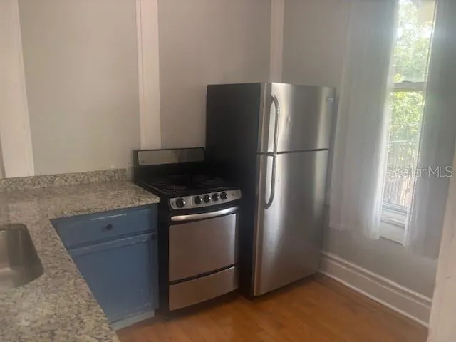 a kitchen with metallic refrigerator and window