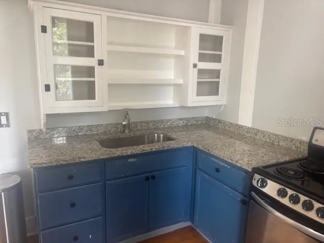 a kitchen with granite countertop a sink stainless steel appliances and cabinets