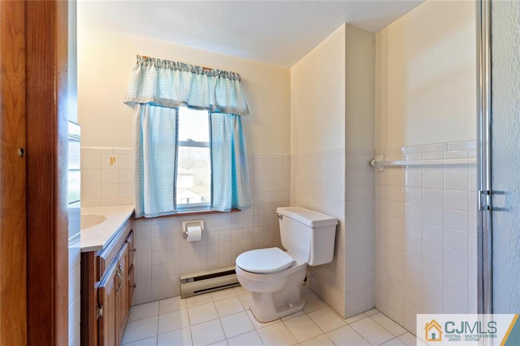 68 Middle Hill Road Colonia, NJ 07067 - Photo 20 of 33 a bathroom with a toilet sink a mirror and a shower