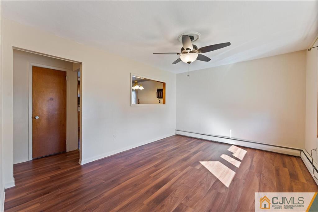 68 Middle Hill Road Colonia, NJ 07067 - Photo 4 of 33 an empty room with wooden floor chandelier fan and windows