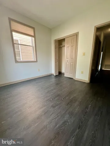 an empty room with wooden floor and closet