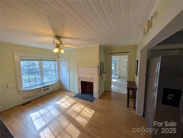 a view of an empty room with a fireplace and a window