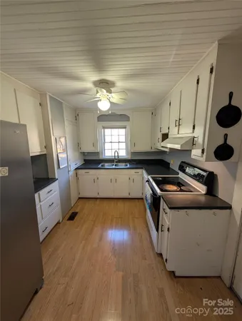 a kitchen with cabinets and wooden floor