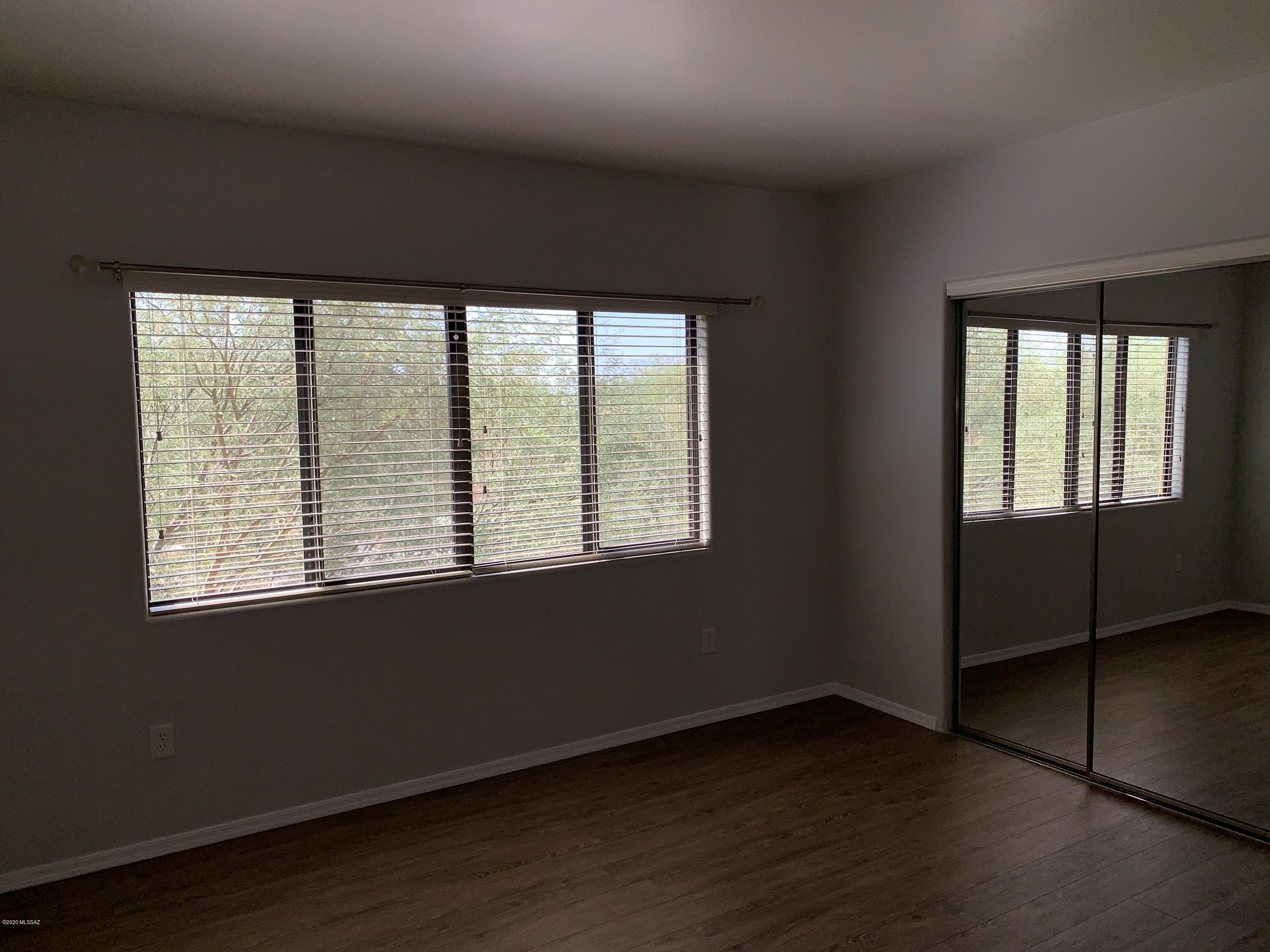 4181 North Fortune Loop Tucson, AZ 85719 - Photo 21 of 39 an empty room with wooden floor and windows