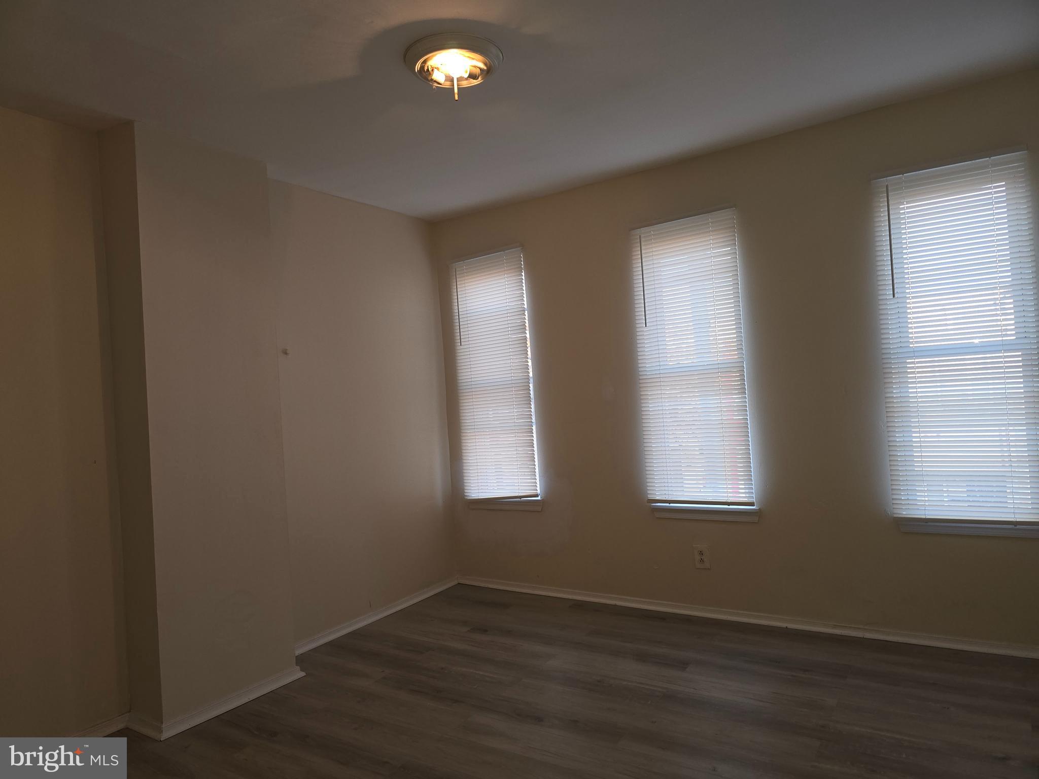 340 South Woodyear Street Baltimore, MD 21223 - Photo 11 of 19 an empty room with wooden floor and windows