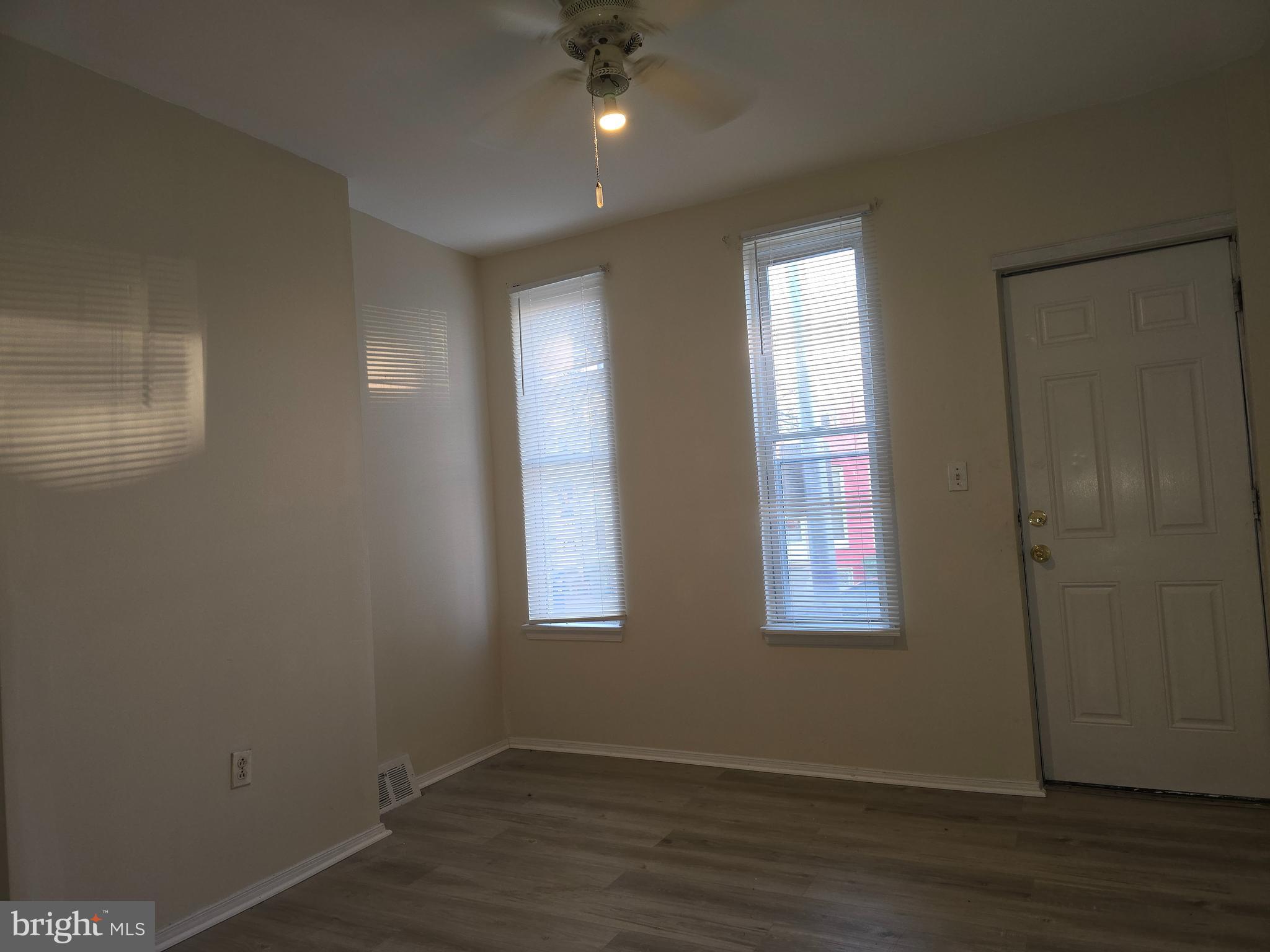 340 South Woodyear Street Baltimore, MD 21223 - Photo 2 of 19 an empty room with wooden floor and windows
