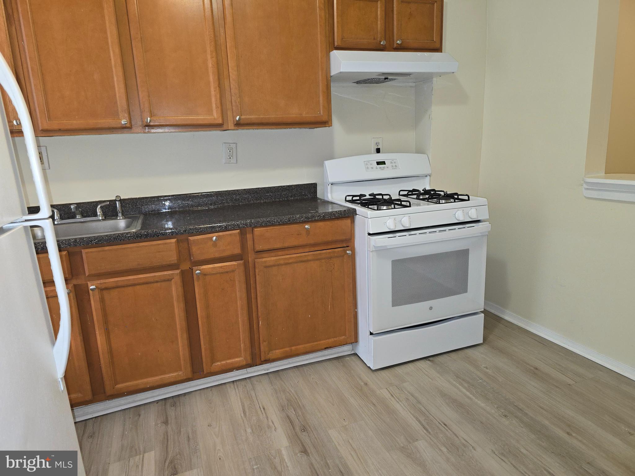 340 South Woodyear Street Baltimore, MD 21223 - Photo 6 of 19 a kitchen with granite countertop white cabinets and white appliances