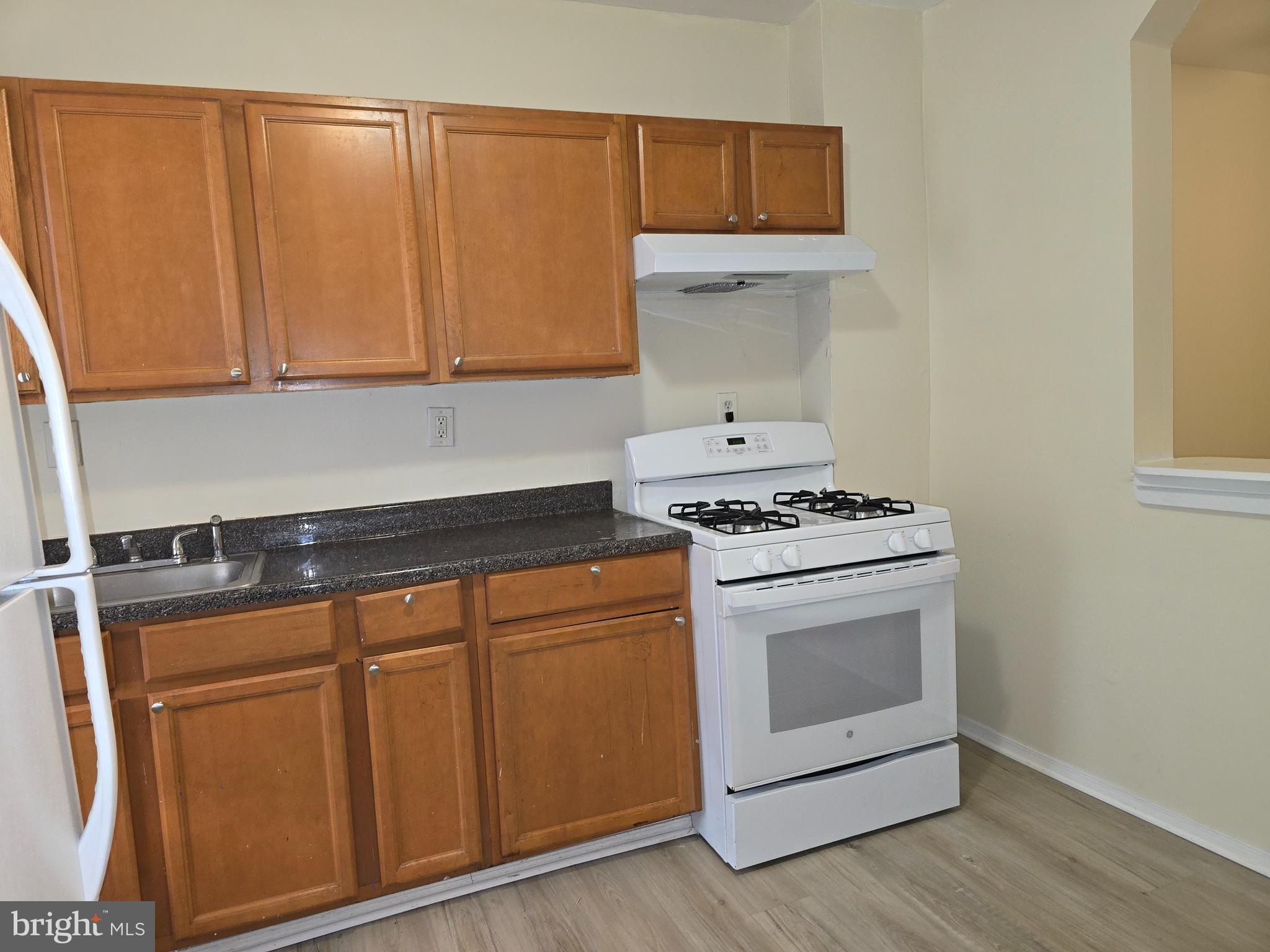 340 South Woodyear Street Baltimore, MD 21223 - Photo 7 of 19 a kitchen with granite countertop cabinets and white appliances