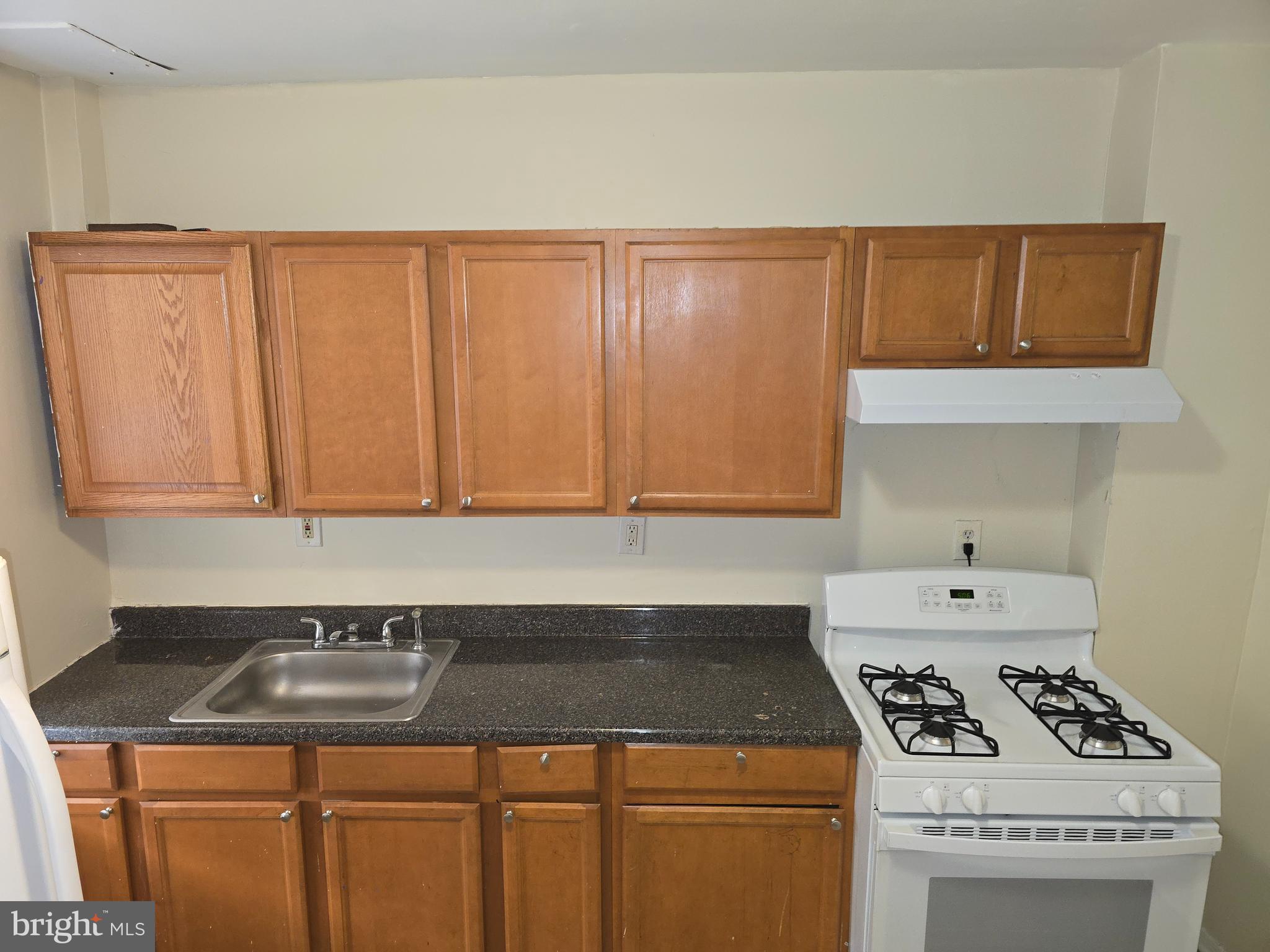 340 South Woodyear Street Baltimore, MD 21223 - Photo 9 of 19 a kitchen with a sink a stove cabinets and white countertops