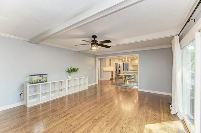a view of a livingroom with wooden floor and a ceiling fan