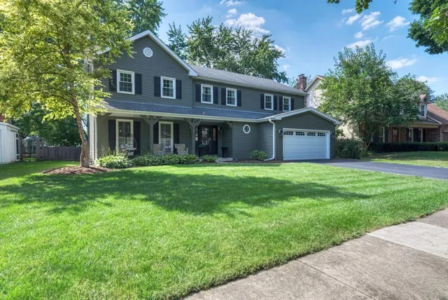 a front view of a house with a yard and trees