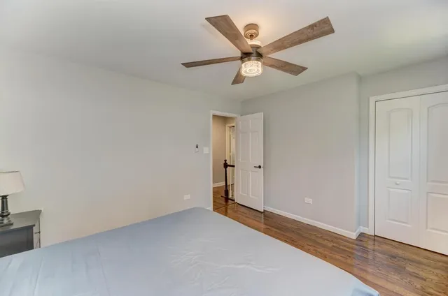 an empty room with closet and a chandelier fan