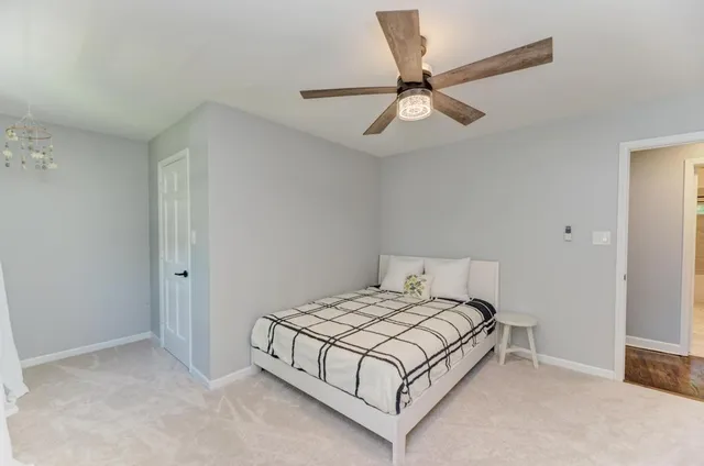 a bedroom with a bed and a ceiling fan
