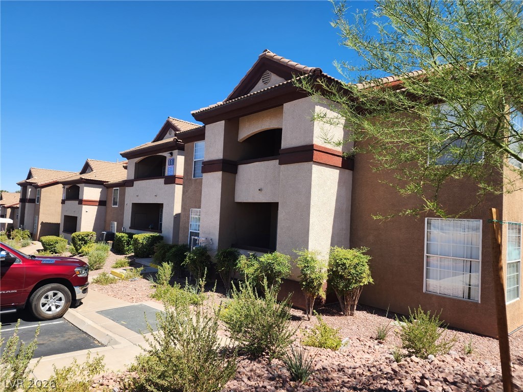 231 West Horizon Ridge Parkway, Unit 1127 Henderson, NV 89012 - Photo 2 of 39 A row of apartment buildings with Mediterranean-inspired architecture and desert landscaping.