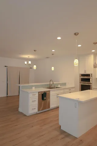 a large kitchen with kitchen island a stove a sink and a refrigerator