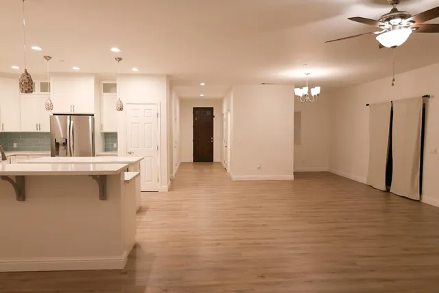 a view of a kitchen with kitchen island a sink stainless steel appliances and cabinets