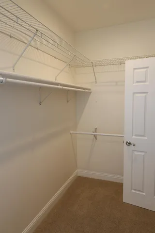 a view of walk in closet with empty racks