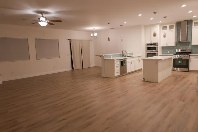 a view of kitchen with stainless steel appliances refrigerator stove microwave and cabinets