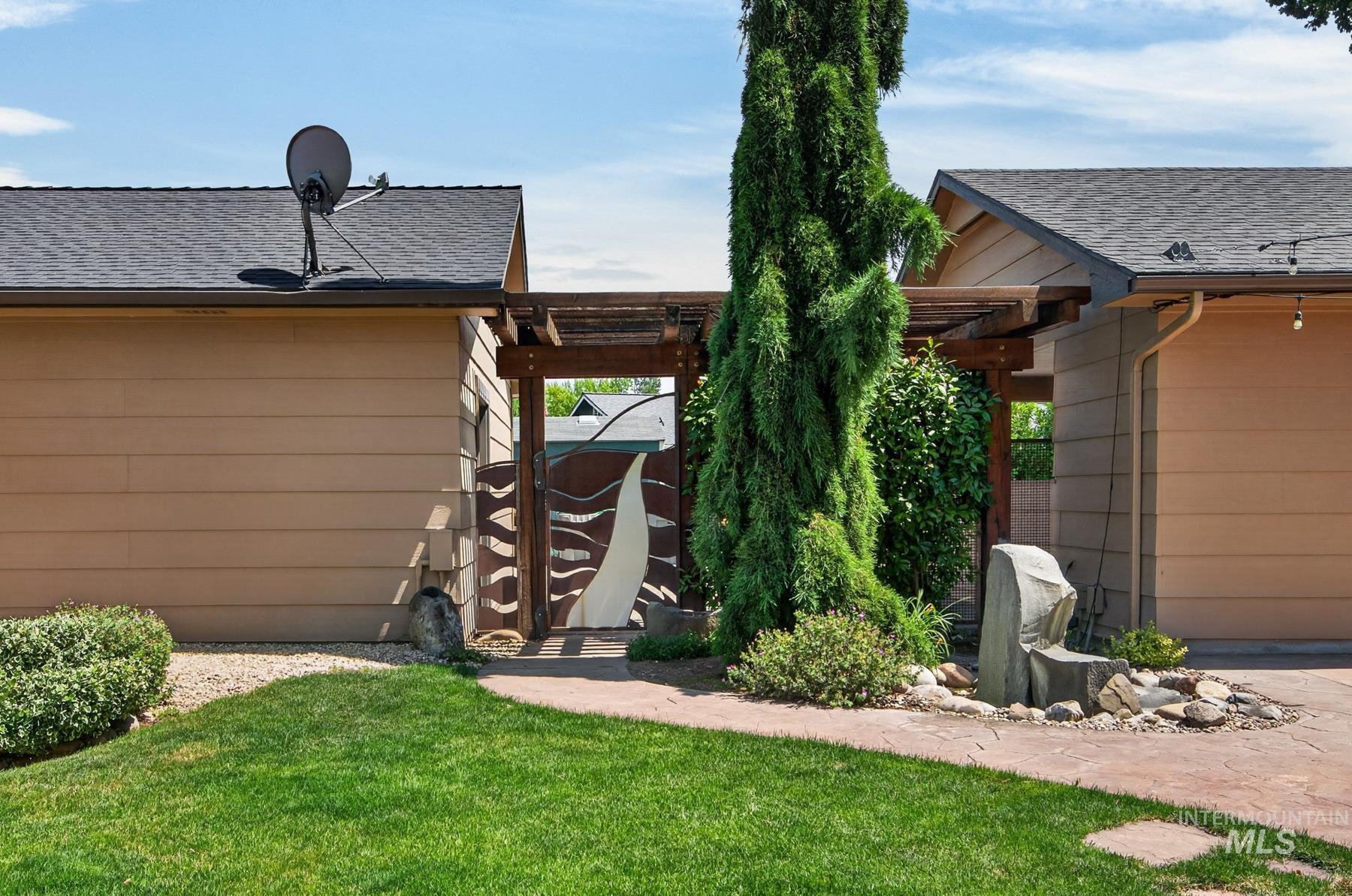 9622 Delaware Street Boise, ID 83709 - Photo 35 of 48 Side yard featuring a custom artistic gate, an overhead pergola, and a rock water feature