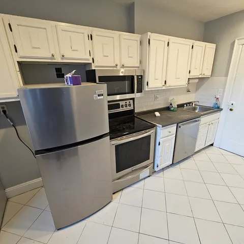 a kitchen with stainless steel appliances a refrigerator sink and cabinets