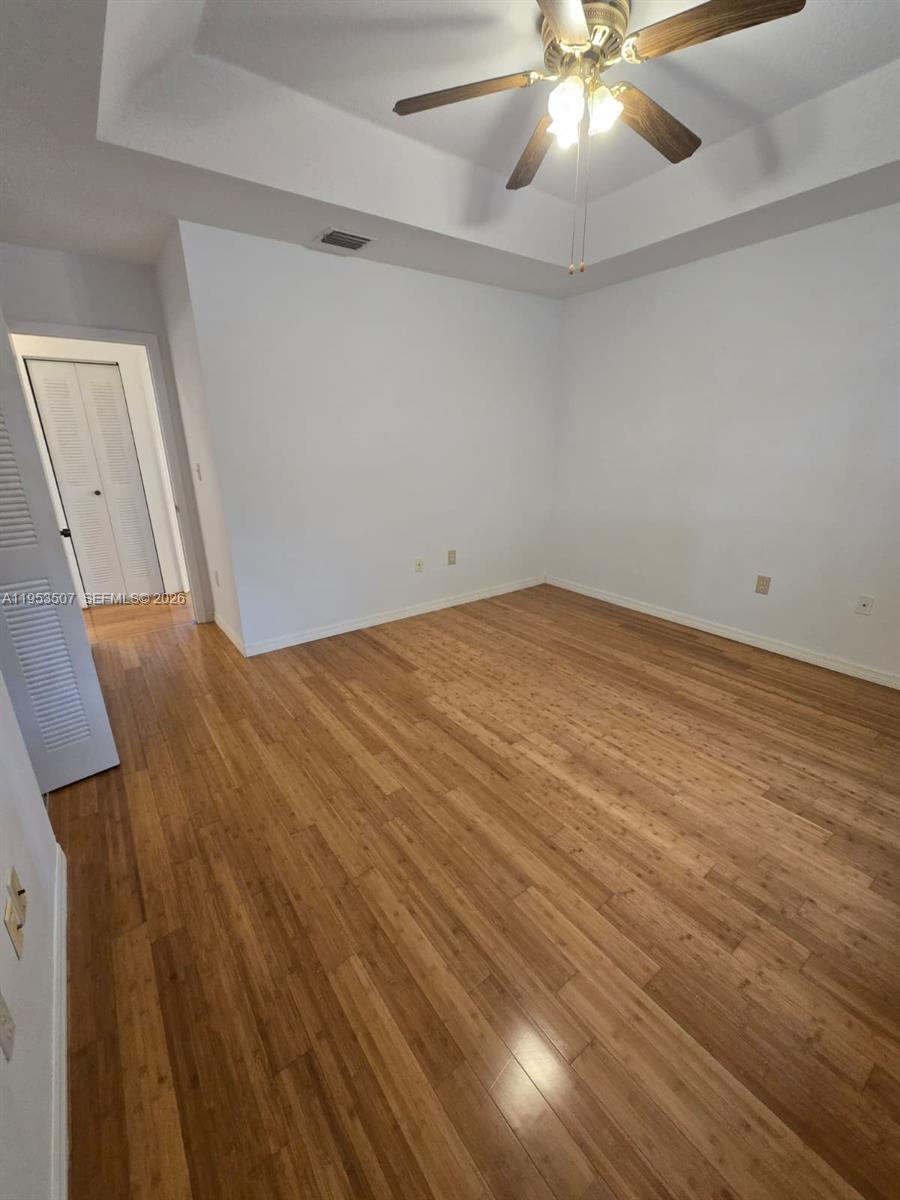 8394 Southwest 152nd Avenue, Unit 35 Miami, FL 33193 - Photo 12 of 24 wooden floor in an empty room with a chandelier fan