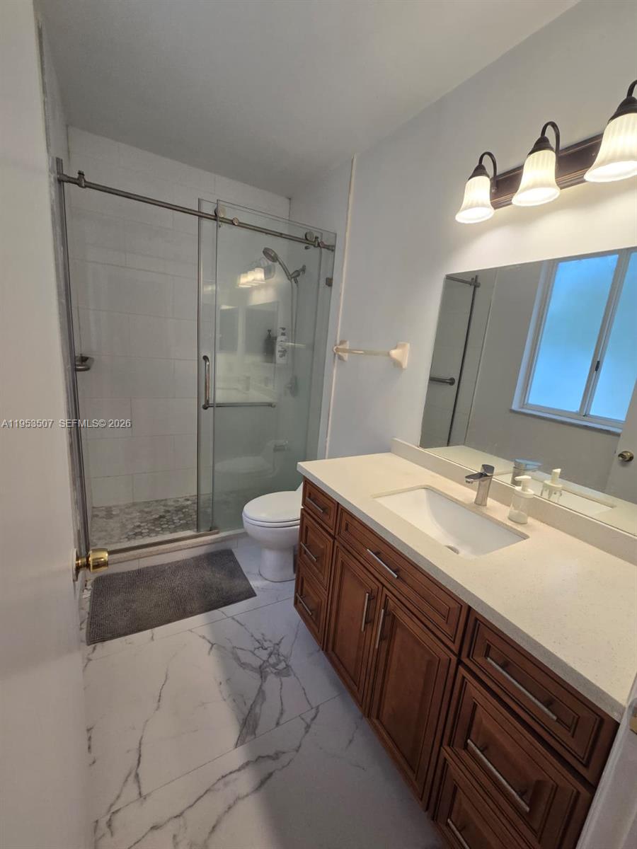 8394 Southwest 152nd Avenue, Unit 35 Miami, FL 33193 - Photo 13 of 24 a bathroom with a sink a toilet and shower