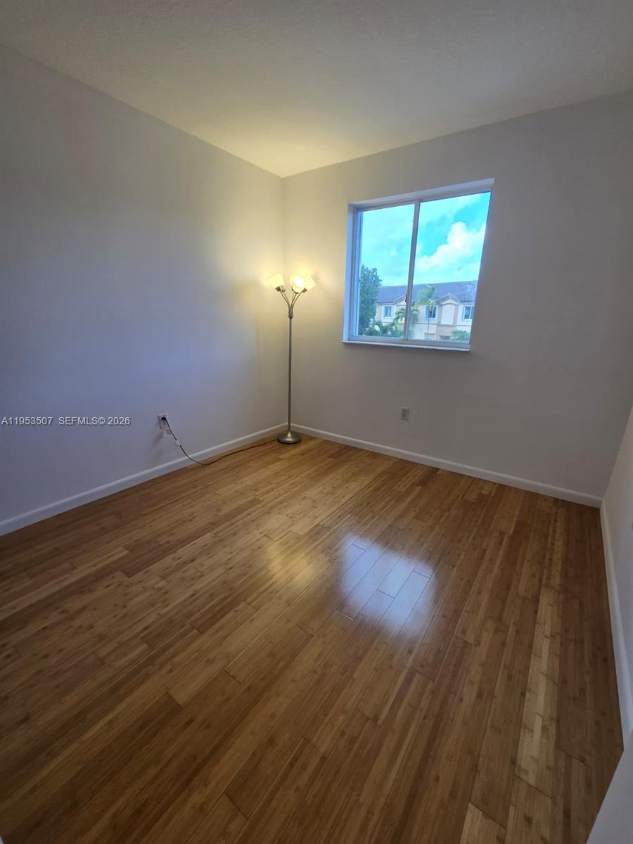 8394 Southwest 152nd Avenue, Unit 35 Miami, FL 33193 - Photo 18 of 24 an empty room with wooden floor and windows
