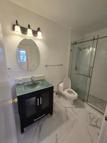 a bathroom with a sink toilet and shower