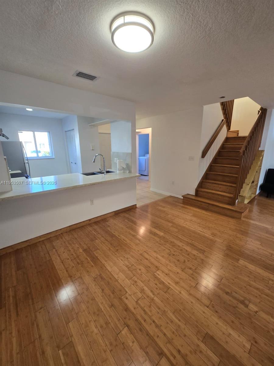 8394 Southwest 152nd Avenue, Unit 35 Miami, FL 33193 - Photo 4 of 24 a view of an empty room with wooden floor and a window