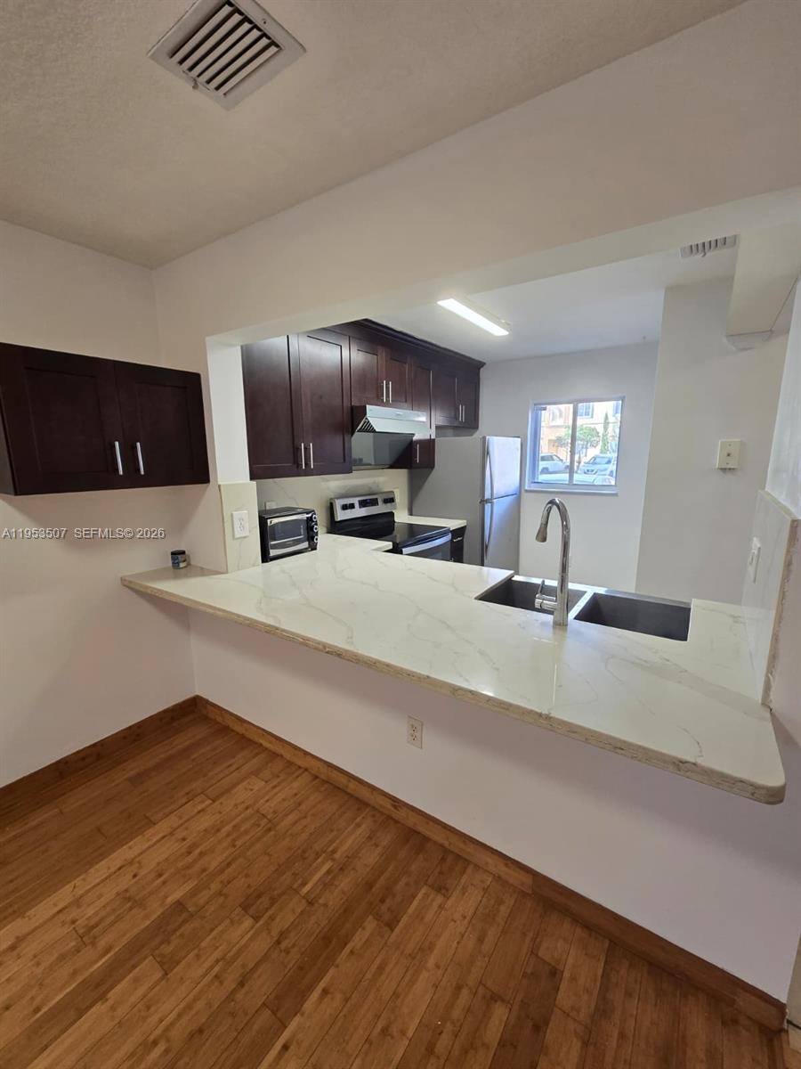 8394 Southwest 152nd Avenue, Unit 35 Miami, FL 33193 - Photo 6 of 24 a view of kitchen with wooden floor and electronic appliances