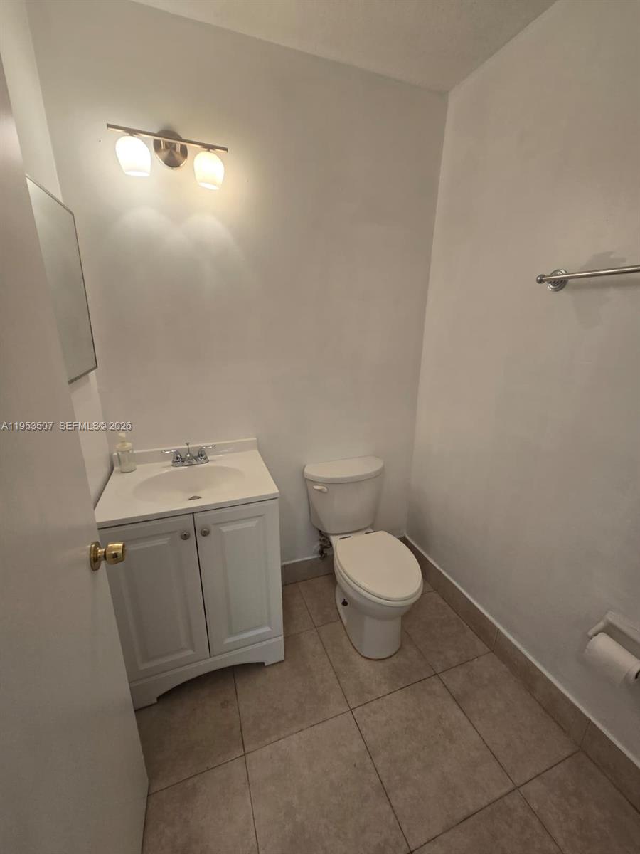 8394 Southwest 152nd Avenue, Unit 35 Miami, FL 33193 - Photo 9 of 24 a bathroom with a toilet sink and vanity