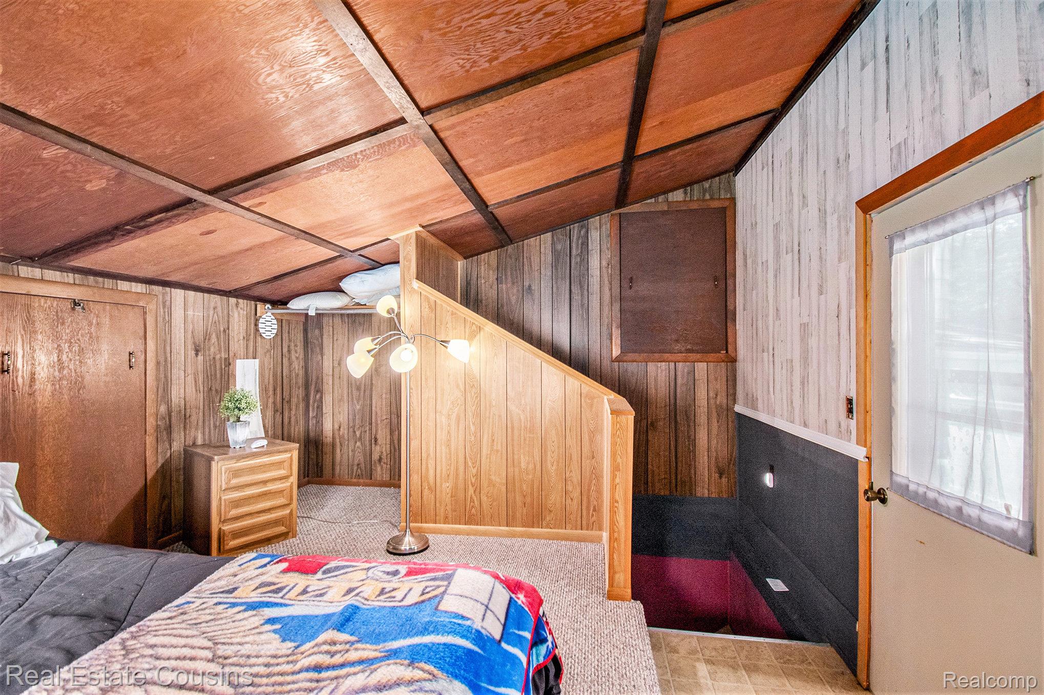 1734 Forest Road Harrison, MI 48625 - Photo 18 of 31 Bedroom with wooden walls and vaulted ceiling