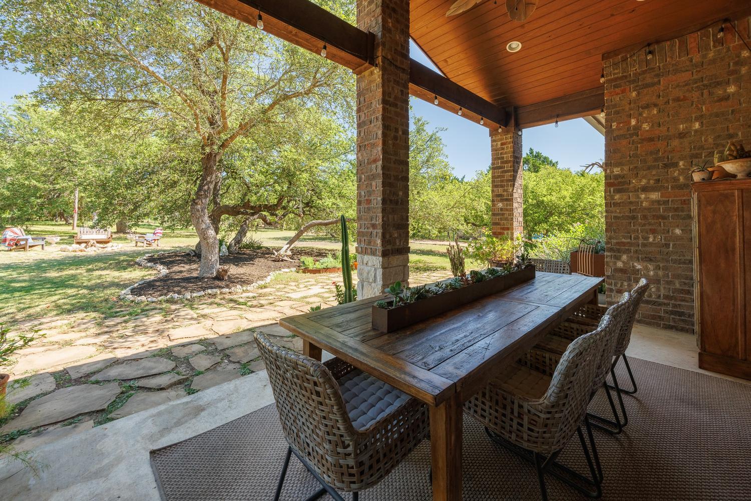 1135 Blue Ridge Drive Dripping Springs, TX 78620 - Photo 31 of 36 A spacious covered patio provides an inviting spot for outdoor dining with views of a verdant yard.