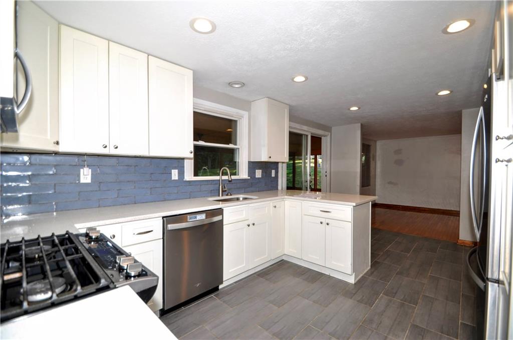 603 Meade Drive Coraopolis, PA 15108 - Photo 11 of 41 a kitchen with white cabinets a sink stove and refrigerator