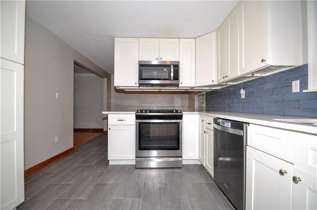 603 Meade Drive Coraopolis, PA 15108 - Photo 14 of 41 a kitchen with granite countertop a stove and a microwave