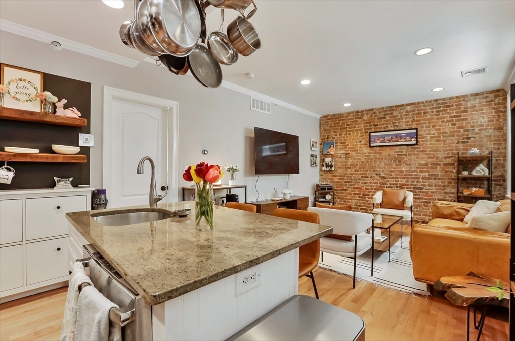 454 Hanover Street, Unit 4 Boston, MA 02113 - Photo 9 of 23 a kitchen with a table chairs flat screen tv and outdoor view