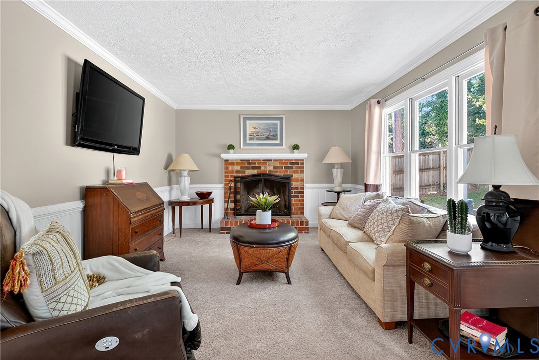 12831 Ashtree Road Midlothian, VA 23114 - Photo 16 of 45 a living room with furniture a flat screen tv and a fireplace