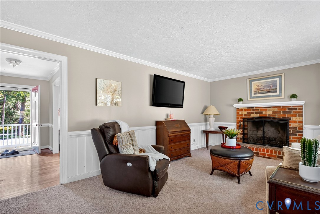 12831 Ashtree Road Midlothian, VA 23114 - Photo 20 of 45 a living room with furniture a fireplace and a flat screen tv