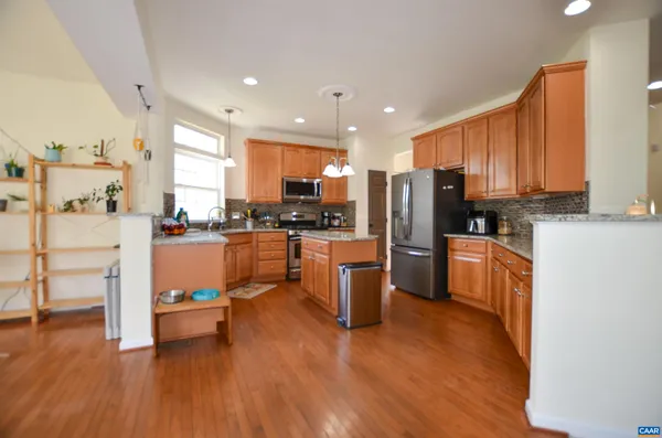 a kitchen with stainless steel appliances wooden floors and wooden cabinets