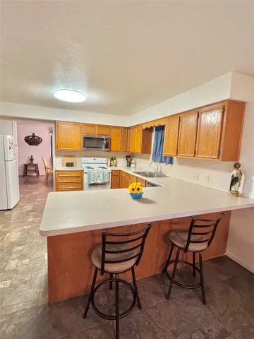 a kitchen with stainless steel appliances kitchen island a stove a table and chairs