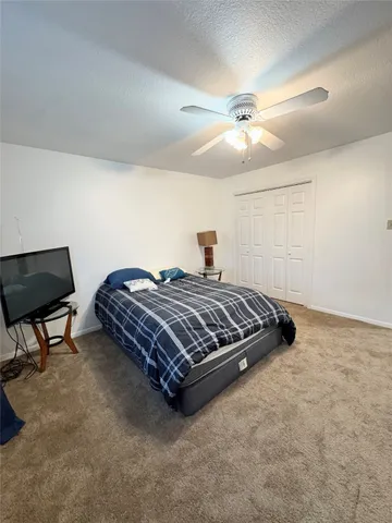 a bedroom with a bed and a ceiling fan