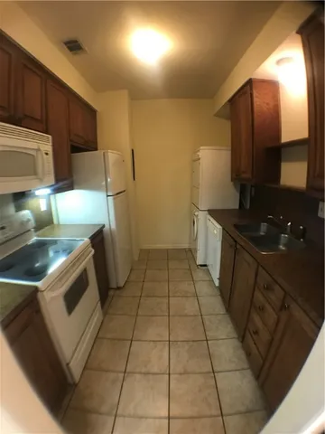a kitchen with a sink a stove and cabinets
