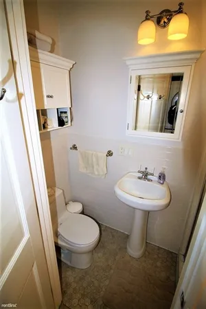 a bathroom with a toilet sink and mirror