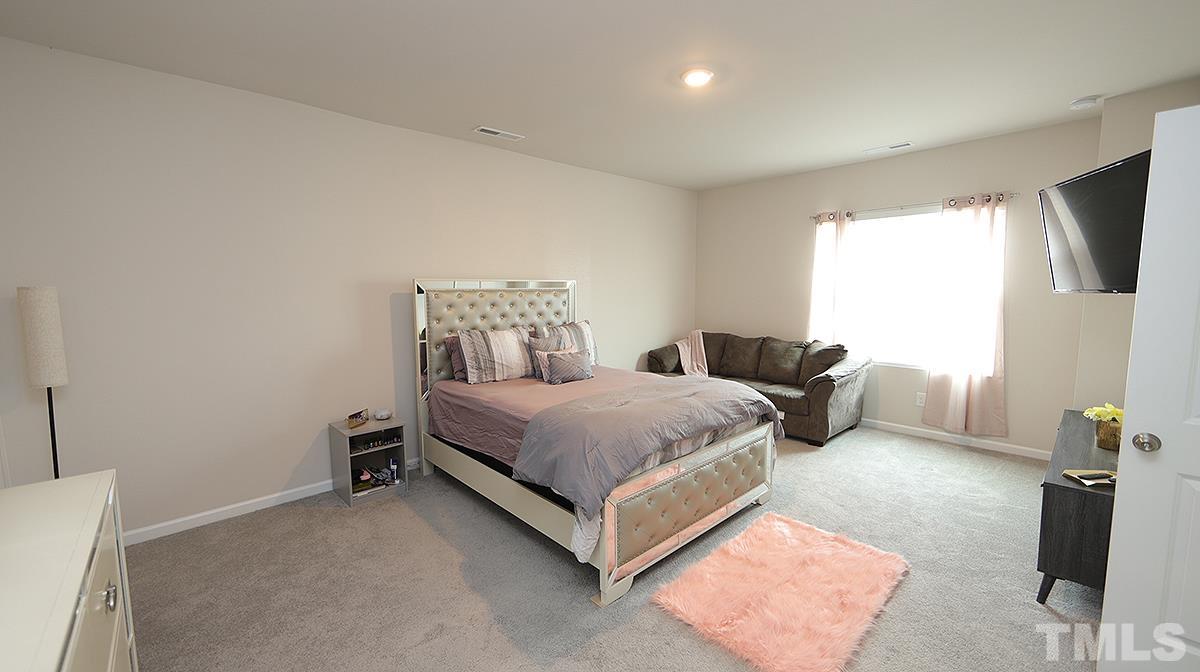 3705 Putman Road Raleigh, NC 27610 - Photo 12 of 19 a spacious bedroom with a bed and a window