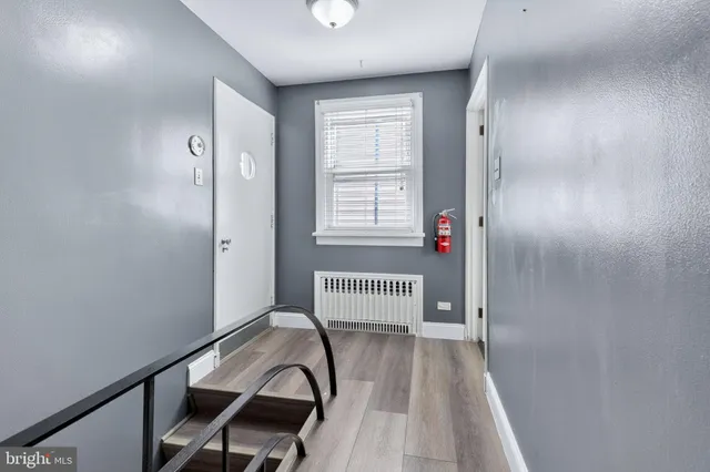 a view of a hallway with wooden floor and entryway
