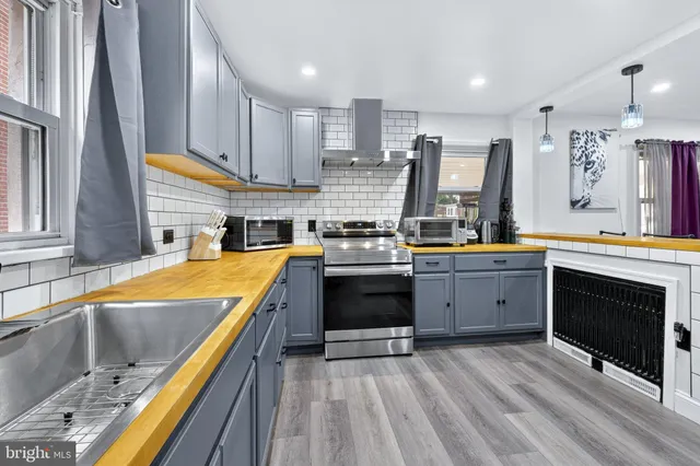 a kitchen with stainless steel appliances kitchen island granite countertop a stove and a sink