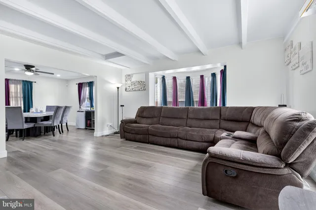 a living room with furniture and a dining table with kitchen view